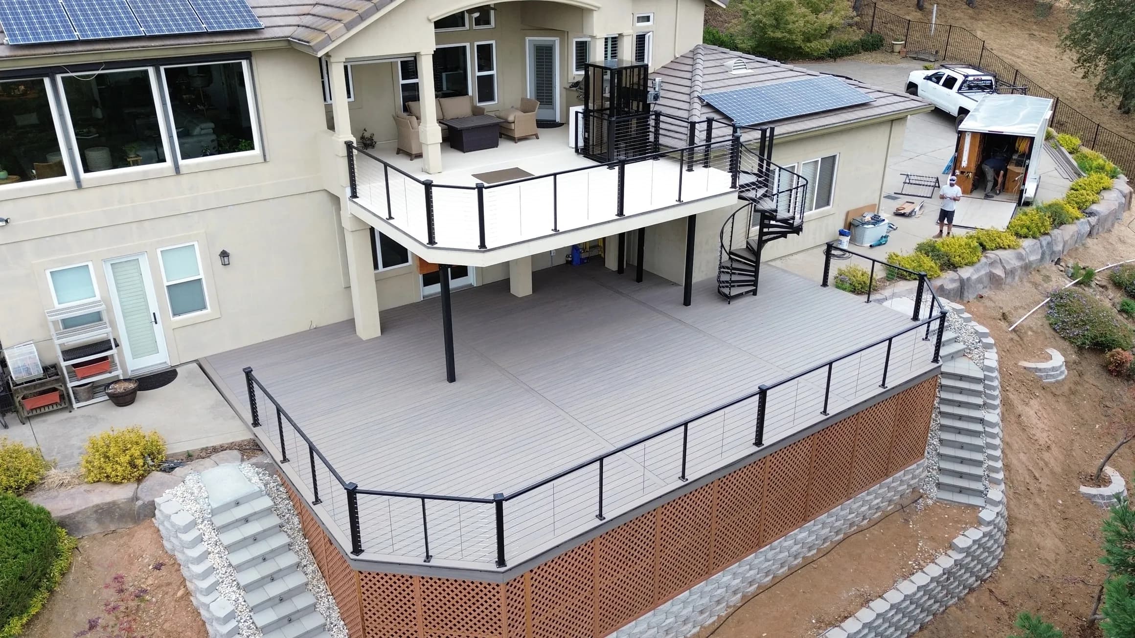 Elevated composite deck with metal railing above a stone retaining wall, built by Cademartori Construction in Placerville
