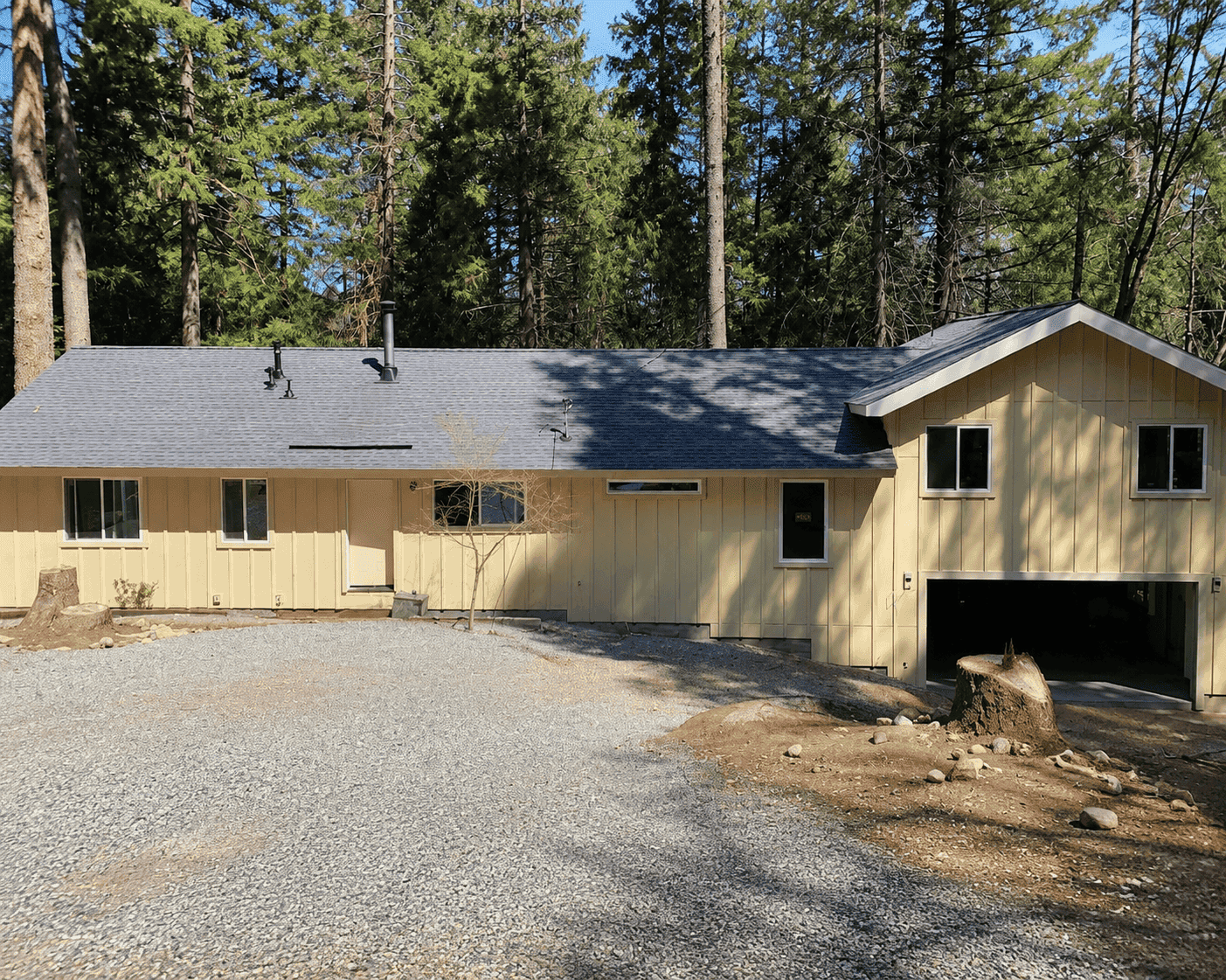 The finished home with board and batten siding and a new garage